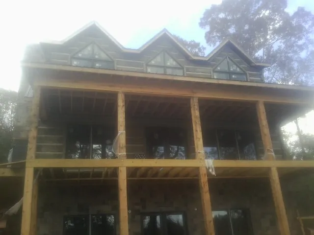 Dormers and porch framing on a large log home under construction — Roof Coating work by our crew in Rivesville