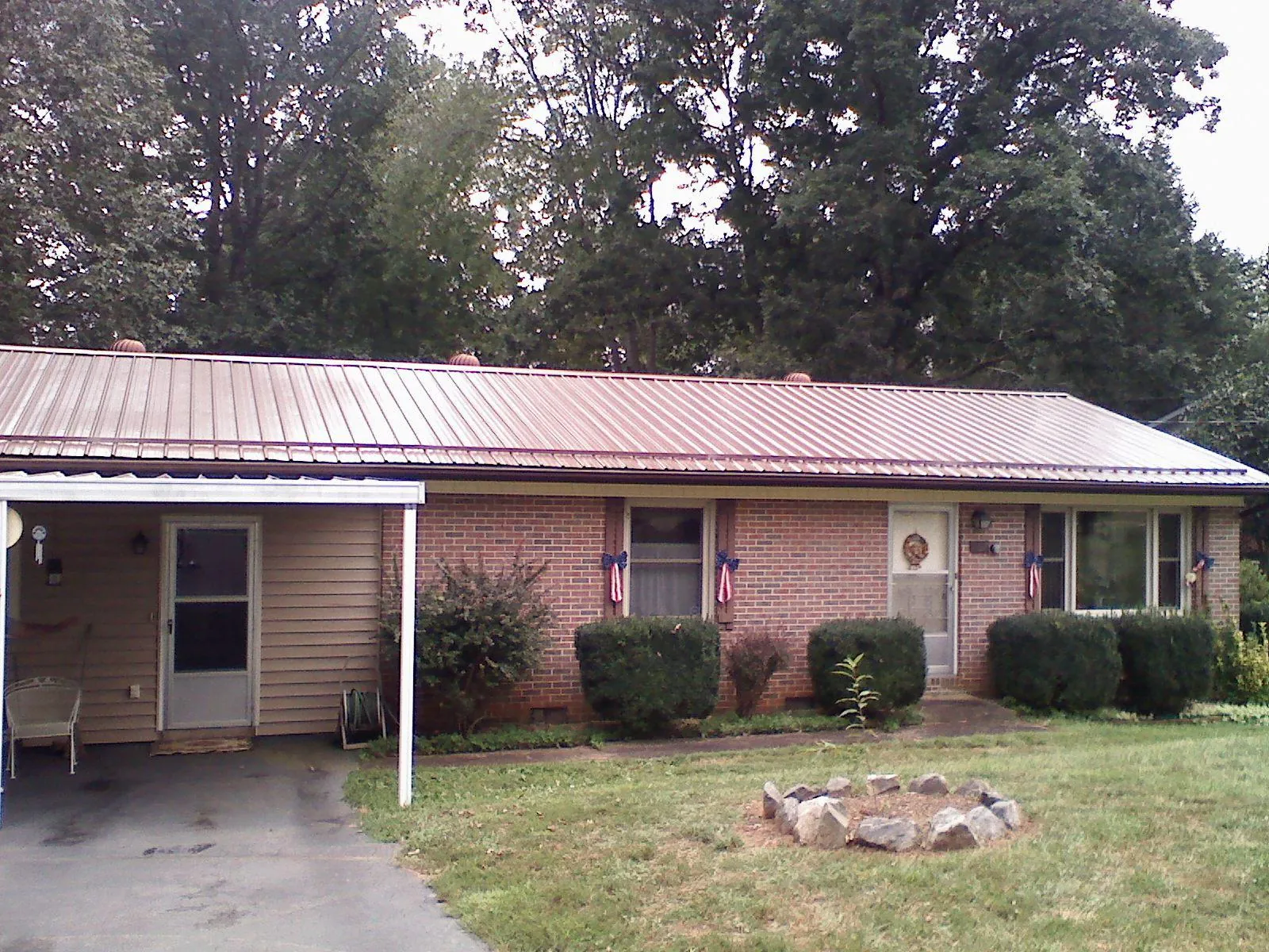 Bronze metal roof and carport on a brick ranch home — Roof Repair work by our crew in Rivesville